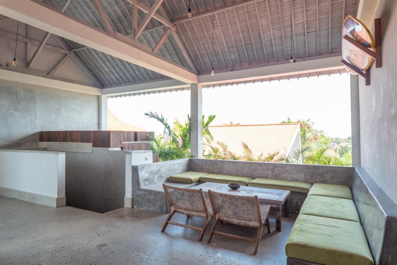 a patio with a table and chairs and a kitchen at 007 Surfhouse Bali in Uluwatu