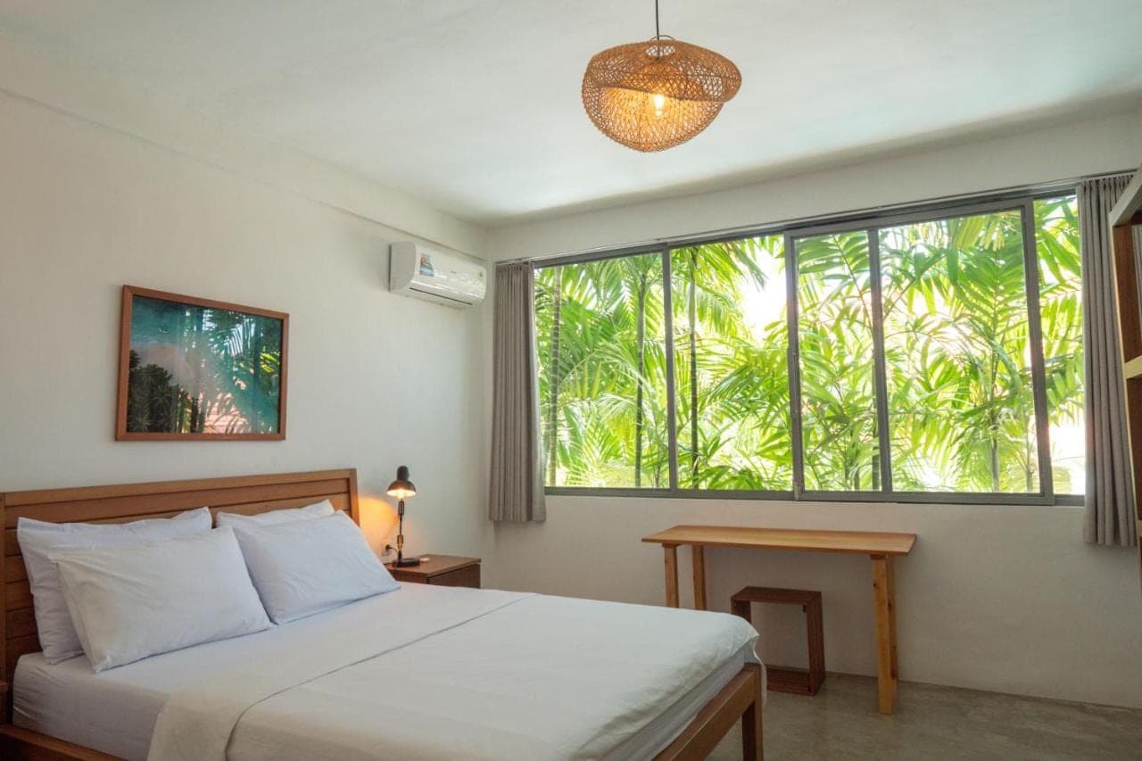 a bedroom with a bed and a large window at 007 Surfhouse Bali in Uluwatu