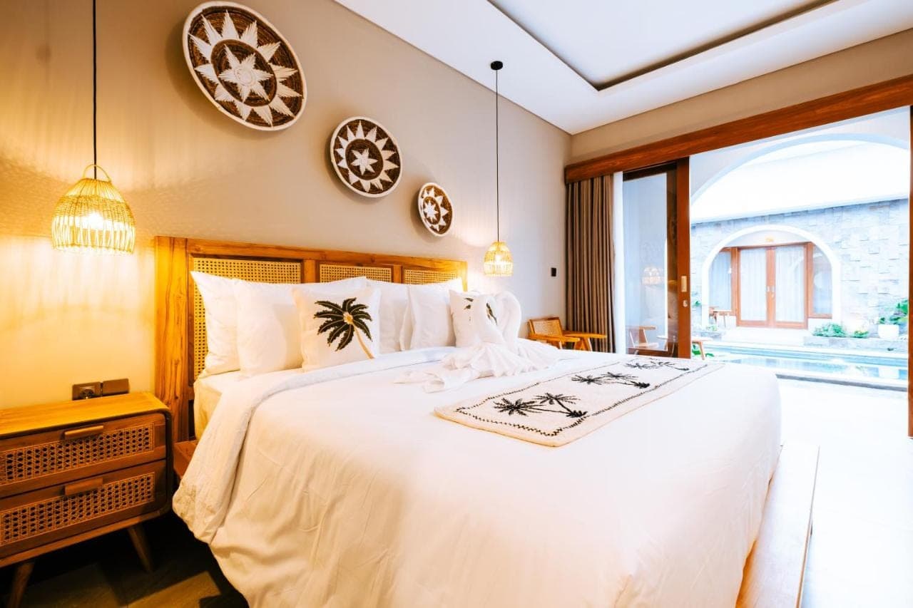 a bedroom with a large white bed and a window at Villa Koura Kuta - 6 Min to Airport Ngurah Rai in Kuta