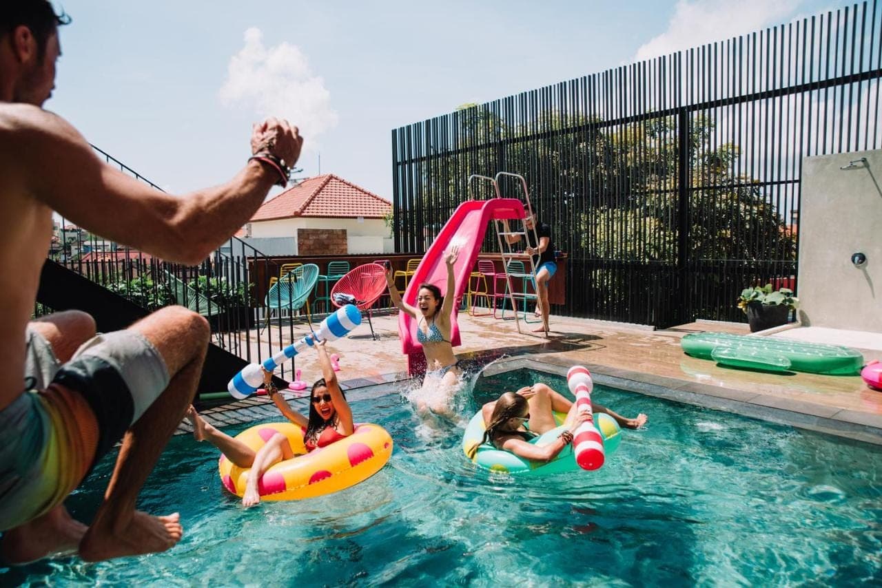 a group of people playing in a swimming pool at Cara Cara Inn in Kuta