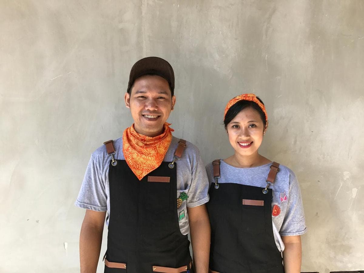 a man and a woman standing next to a wall at Cara Cara Inn in Kuta