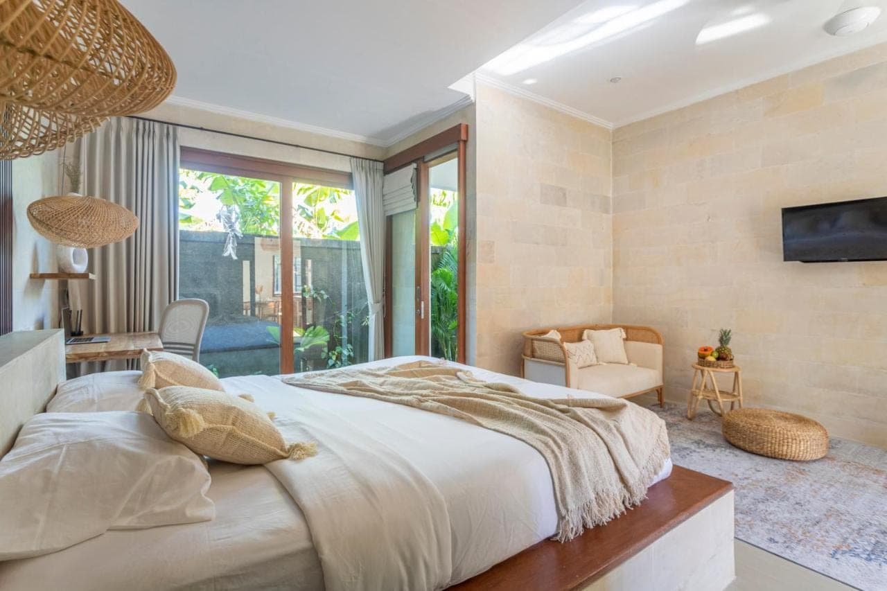 a bedroom with a large bed and a tv at Designer Studio Emy Sanur in Sanur