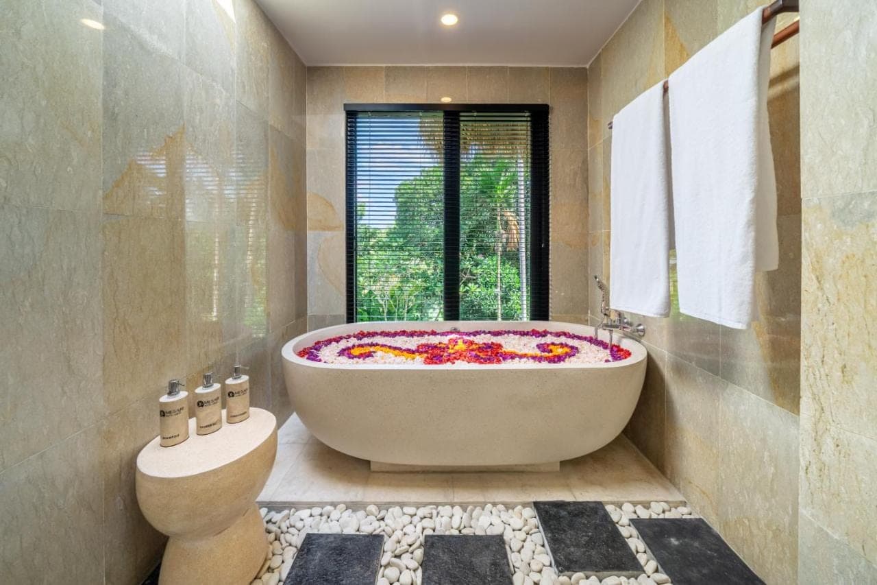a bathroom with a large tub and a window at Mesari Hotel - Rice Terrace Retreat with Pool & Restaurant in Ubud