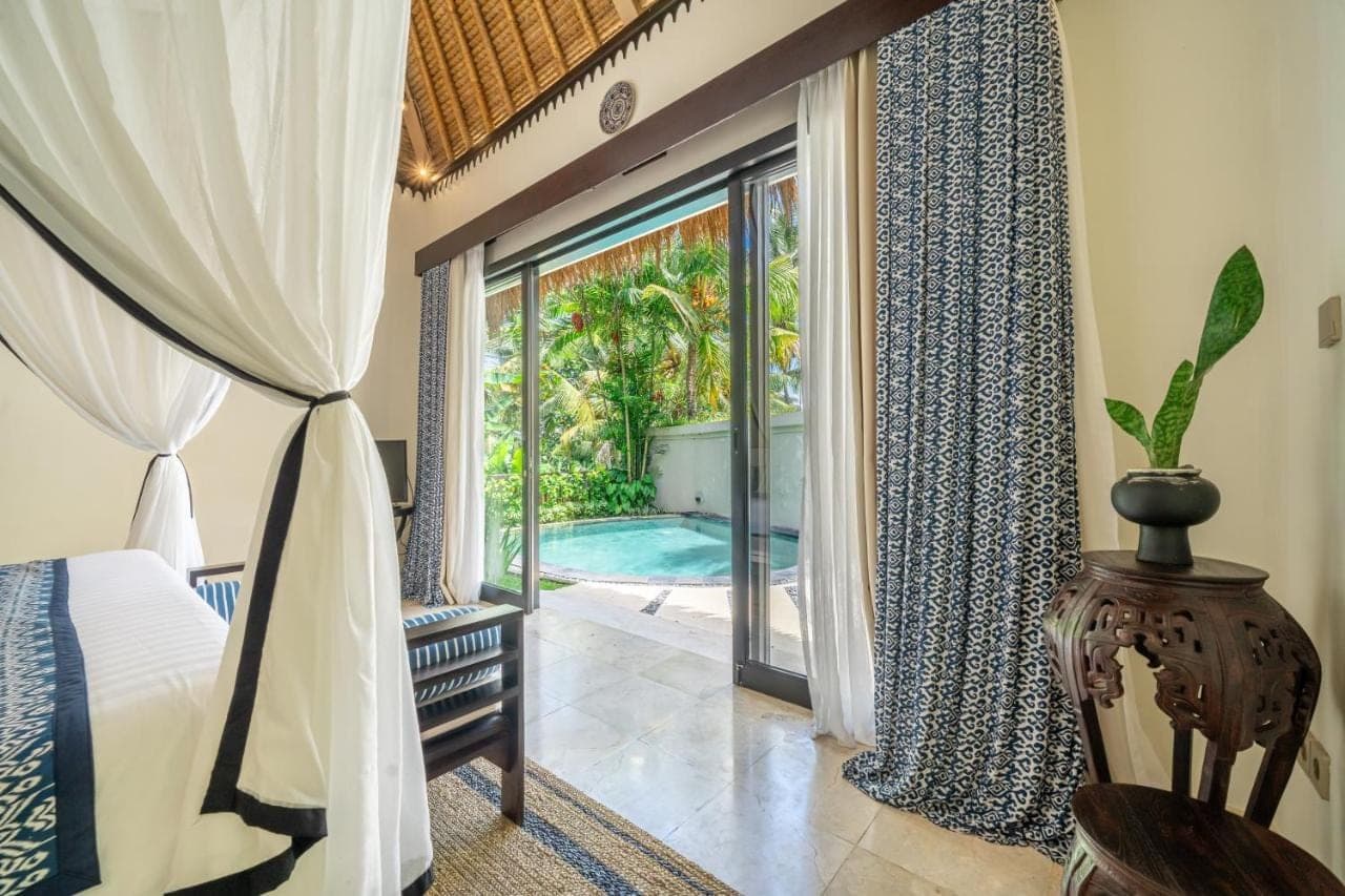 a bedroom with a bed and a sliding glass door at Mesari Hotel - Rice Terrace Retreat with Pool & Restaurant in Ubud