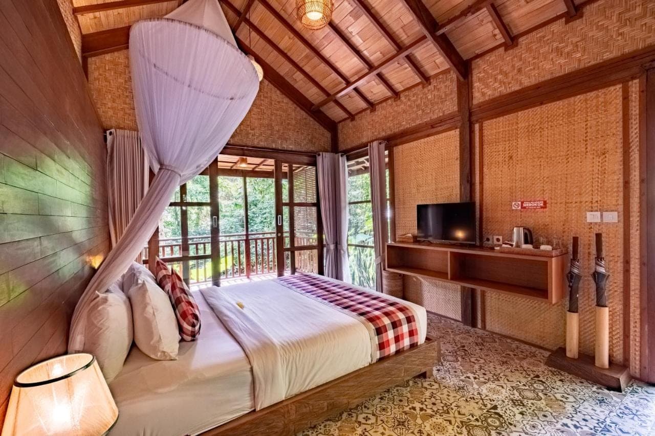 a bedroom with a bed in a room with a window at Villa Ubud Sunshine in Ubud
