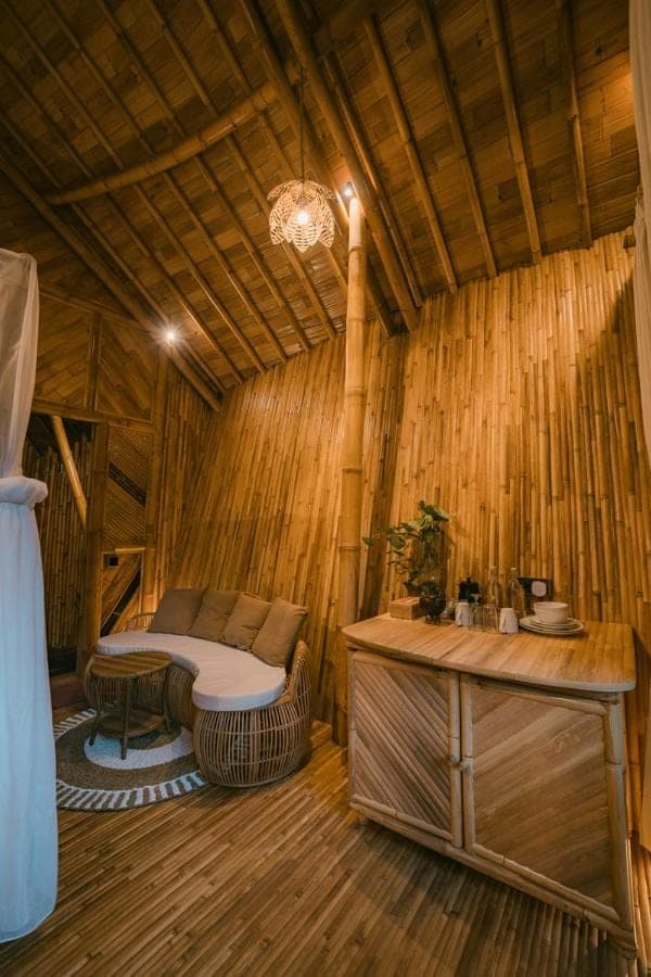 a room with a bed and a table in a room at Trivana Sanctuary by Arcada Bali in Sidemen