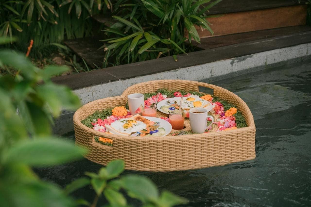 a basket filled with food and drinks in the water at Trivana Sanctuary by Arcada Bali in Sidemen