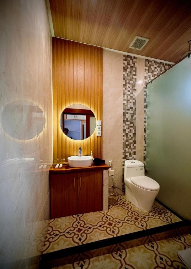 a bathroom with a toilet and a sink and a mirror at Bali Banana Guest House in Canggu