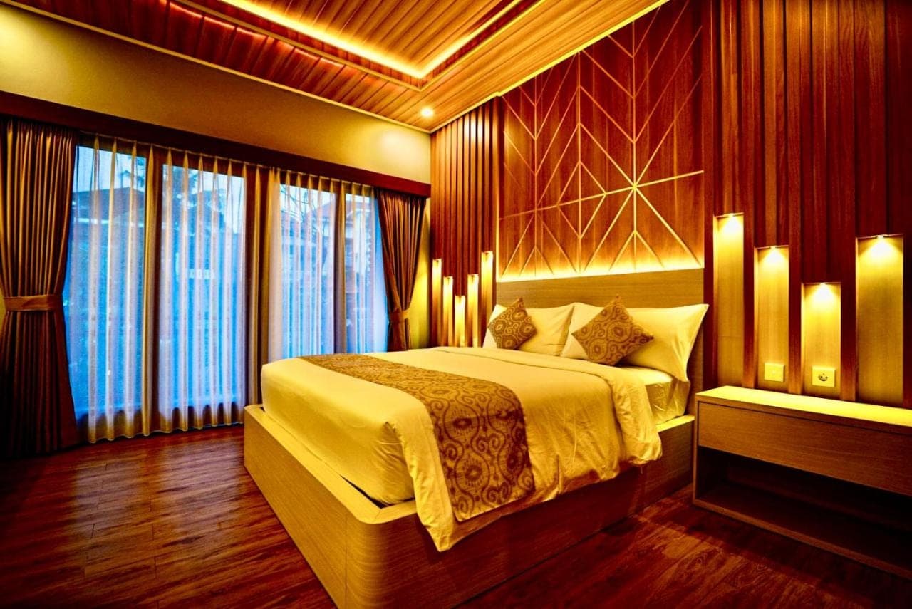 a bedroom with a large bed and a large window at Bali Banana Guest House in Canggu