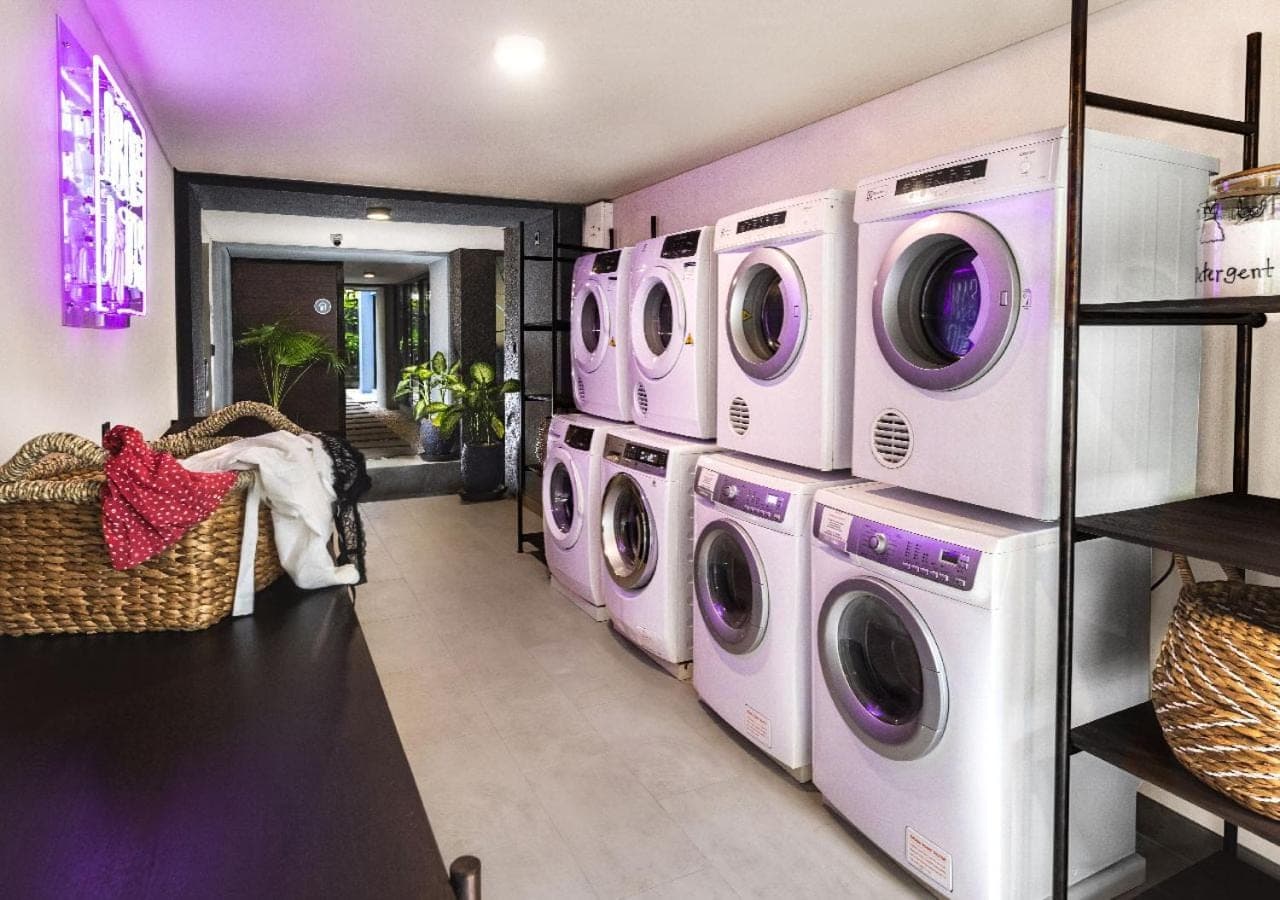 a laundry room with four washers and dryers at MAMAKA Bali in Kuta