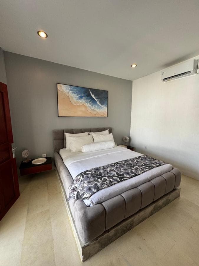 a bedroom with a large bed in a room at Uluwatu Stay's Standard Room #1 in Uluwatu