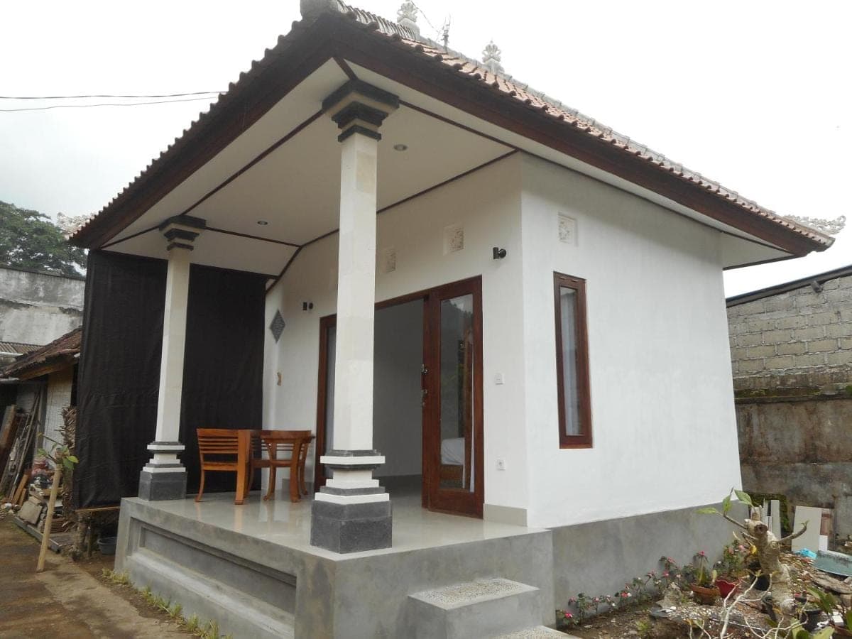 a small white house with a table in it at New Lilastana Homestay in Sidemen