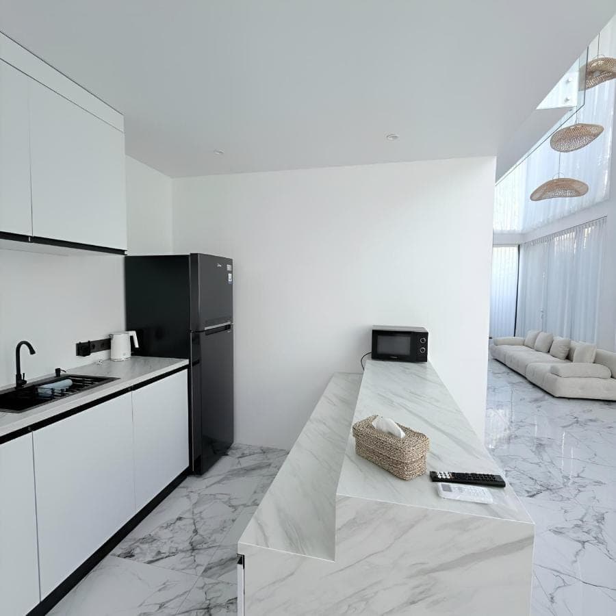 a kitchen with white walls and a counter top at Sun on The Hill By Betterplace in Nusa Dua