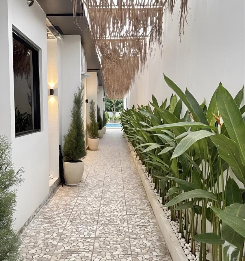 a hallway with potted plants in a building at Sun on The Hill By Betterplace in Nusa Dua