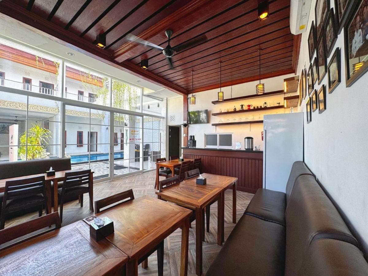a restaurant with tables and chairs and a large window at Brady's B&B Close To Sanur Beach in Sanur