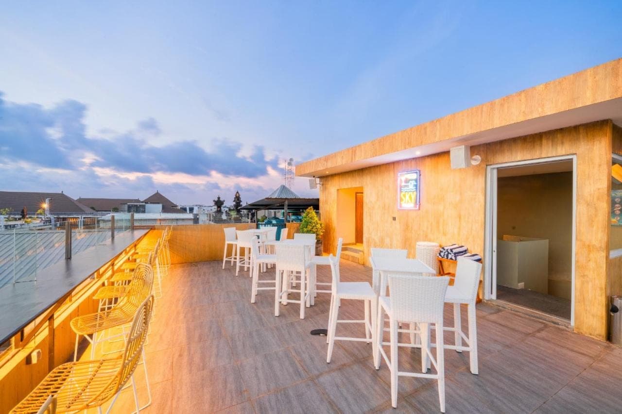 a deck with white chairs and tables on a building at Stark Boutique Hotel and Spa in Kuta