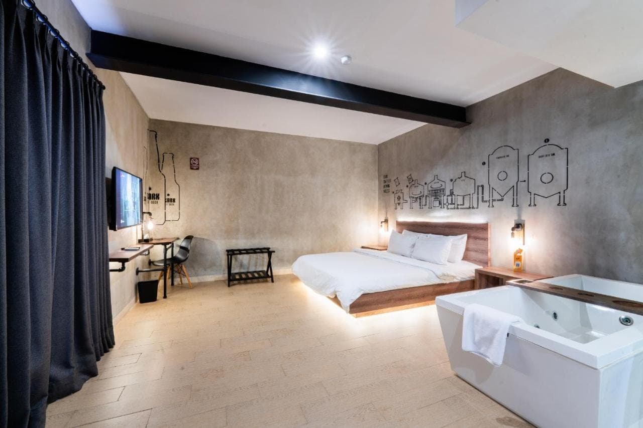 a bedroom with a bed and a tub and a sink at Stark Boutique Hotel and Spa in Kuta