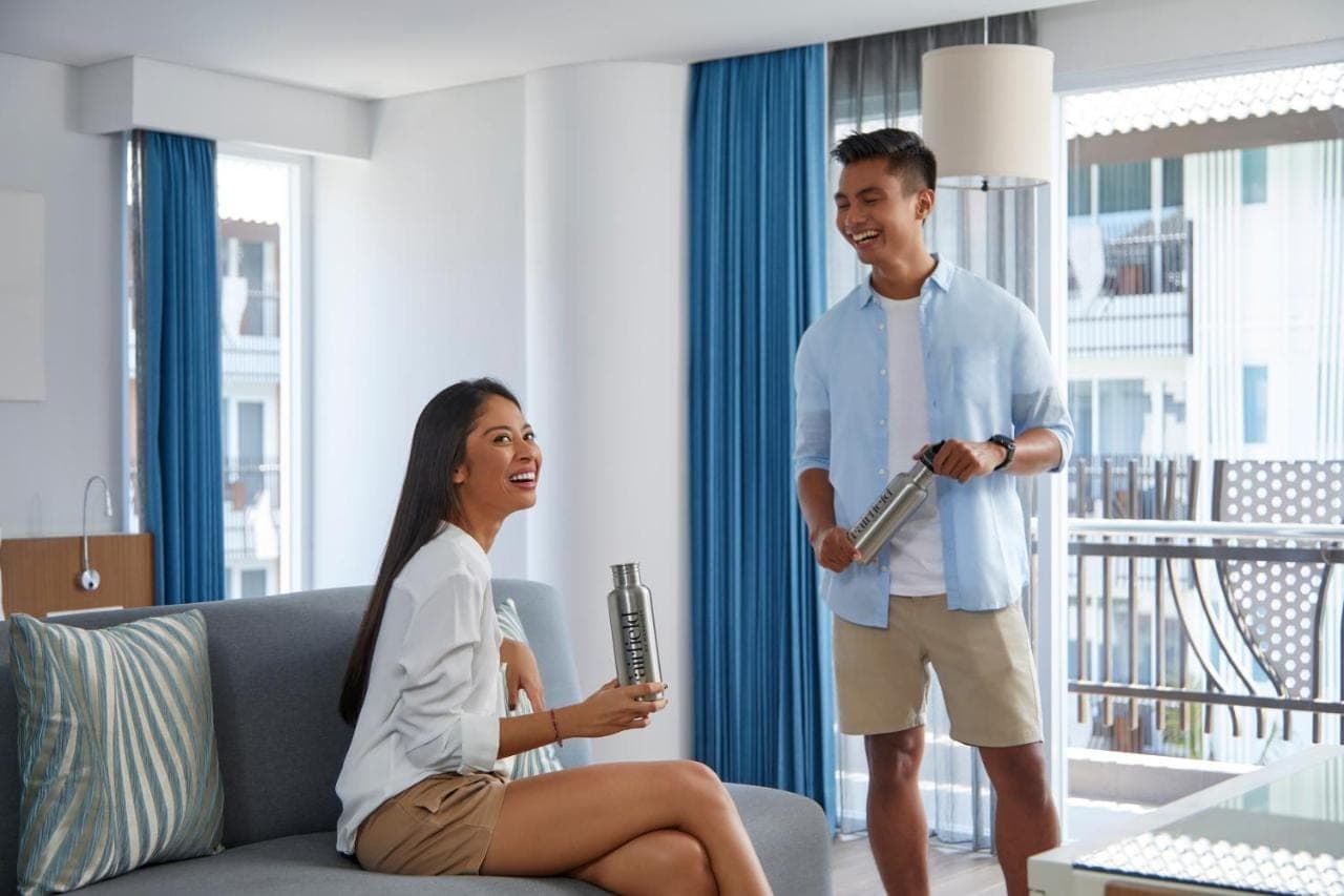 a man and a woman standing in a living room at Fairfield by Marriott Bali Kuta Sunset Road in Kuta