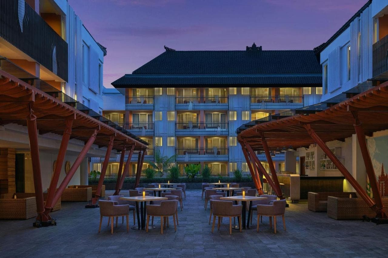 a group of tables and chairs in front of a building at Fairfield by Marriott Bali Kuta Sunset Road in Kuta