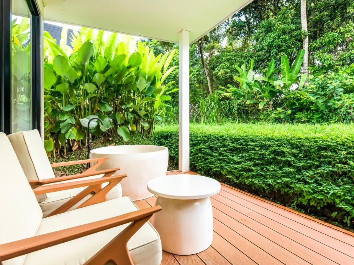 a porch with white chairs and a view of trees at Tanada Resort Ubud by Amithya - Brand New Opened 2026 in Ubud