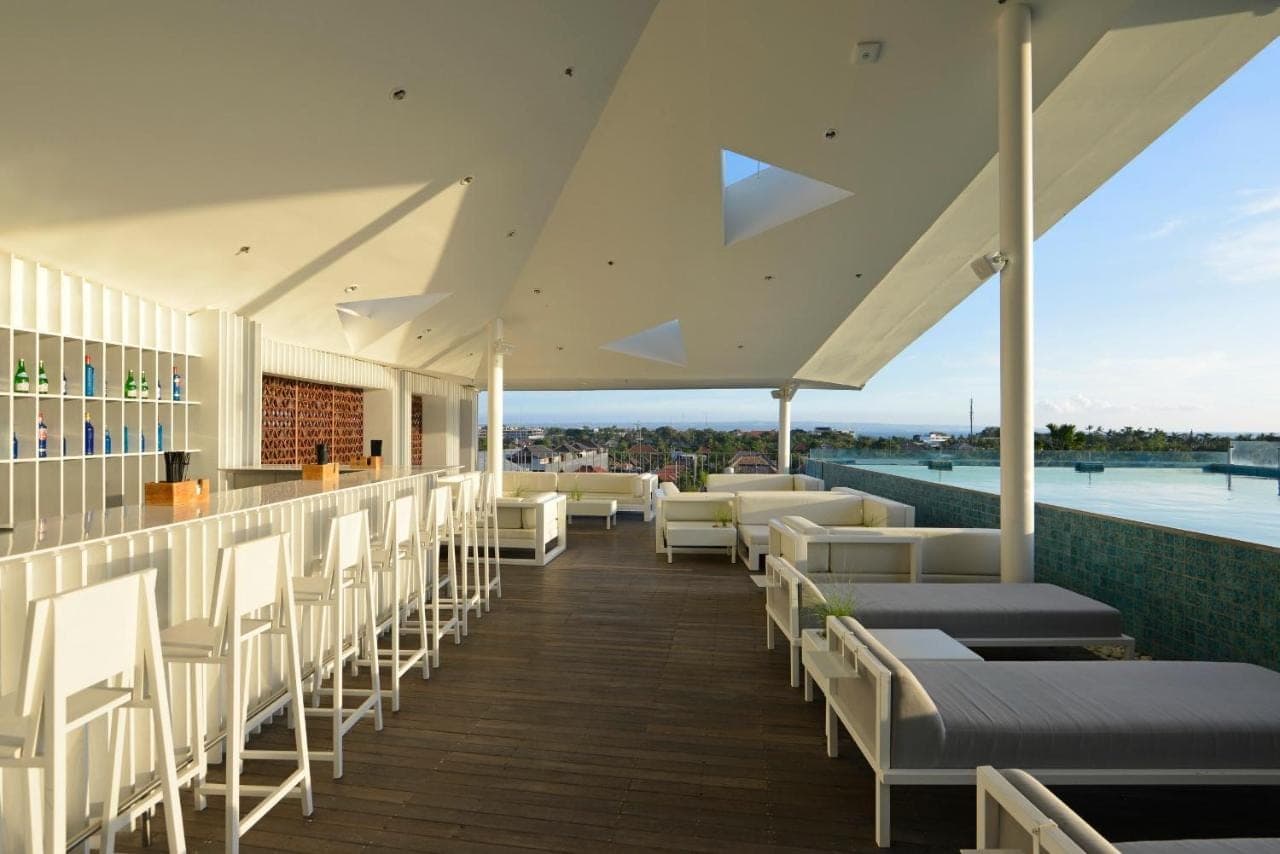 a restaurant with white chairs and a bar with a view at IZE Seminyak by LifestyleRetreats in Seminyak