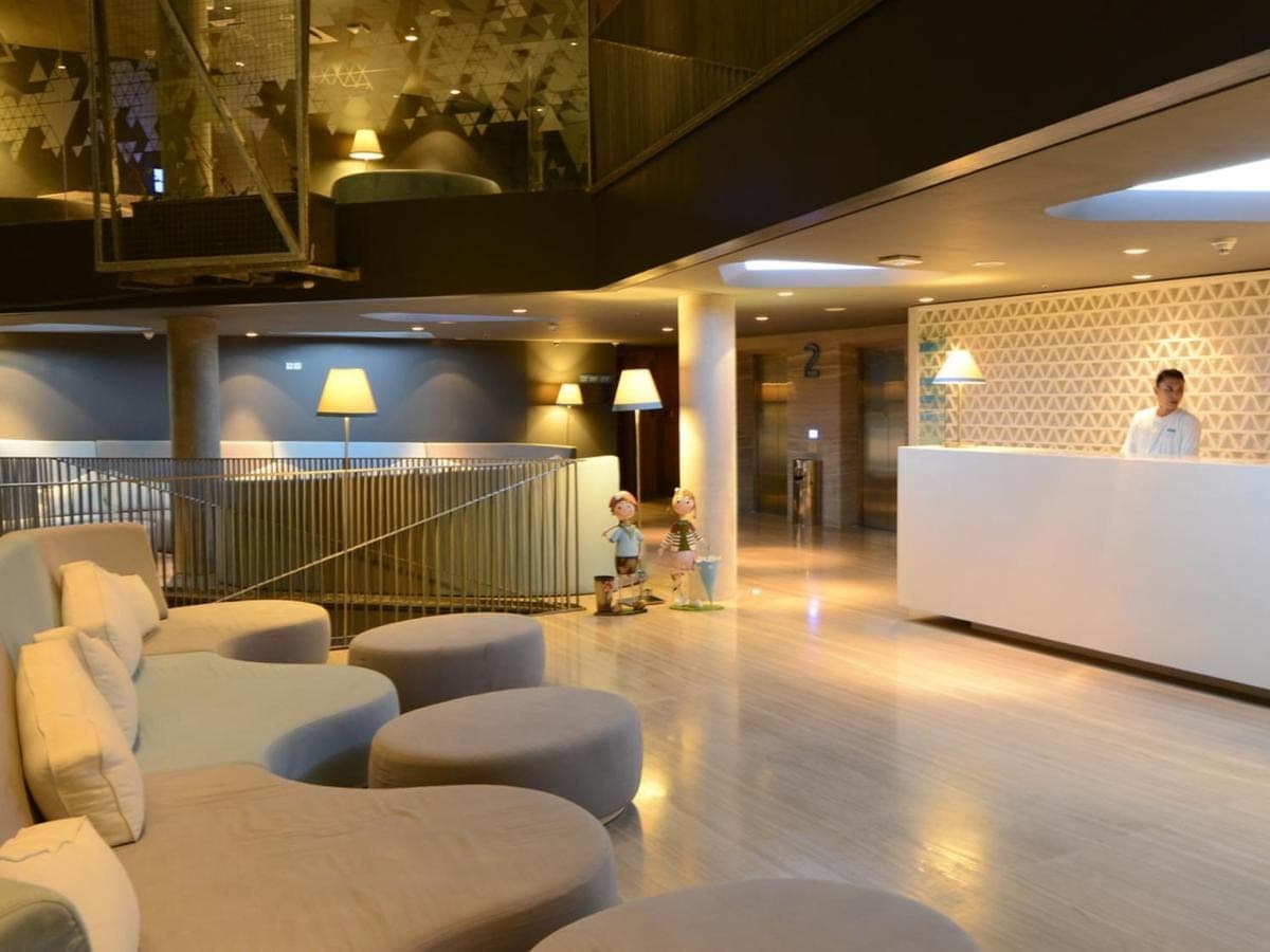 a man standing in a lobby with a child in a room at IZE Seminyak by LifestyleRetreats in Seminyak