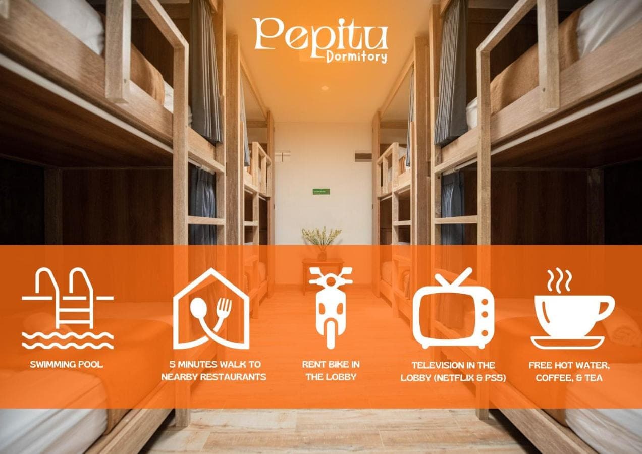 a hallway of a building with signs on the wall at Pepitu Dormitory By Sandat in Kuta