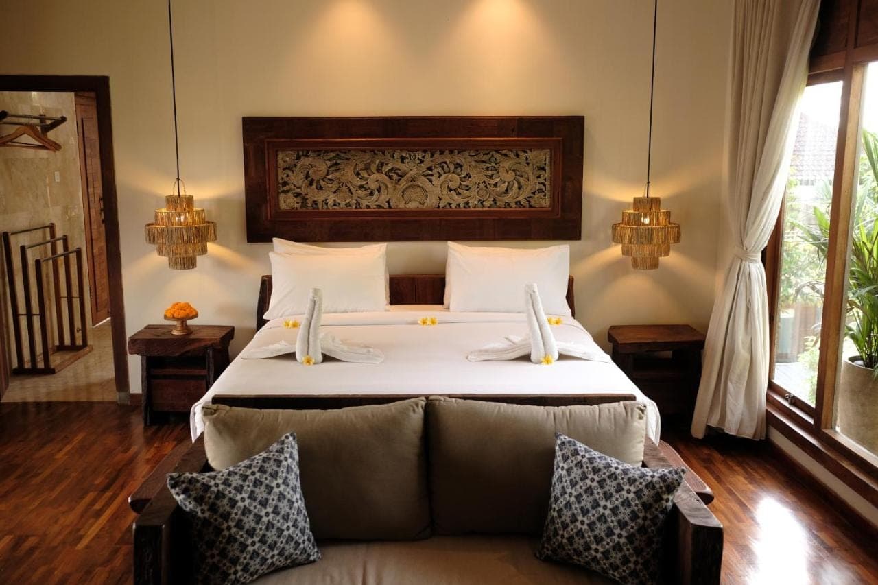 a bedroom with a large bed in a room at Sri Ratih Cottages, CHSE Certified in Ubud