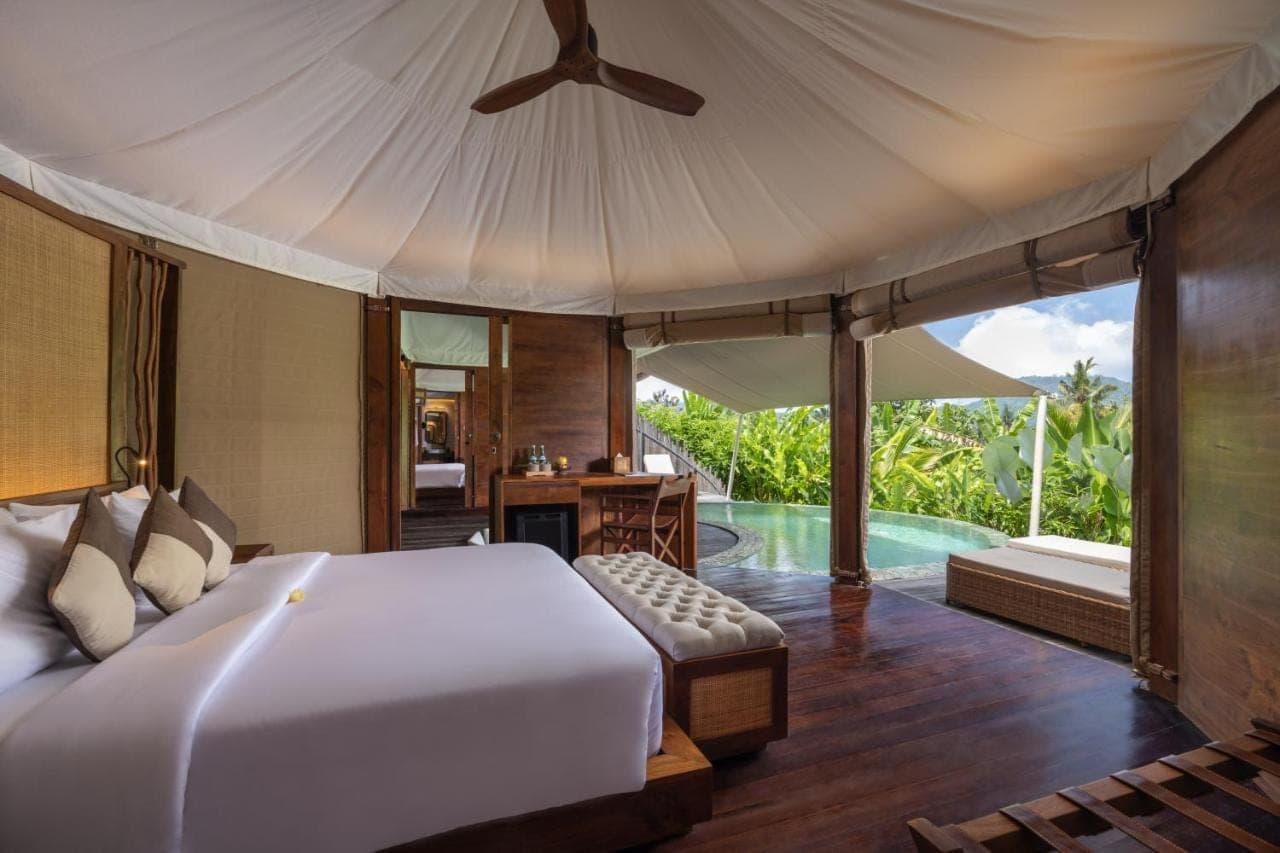 a bedroom with a large bed and a pool at The Wapa Lux Tent in Sidemen