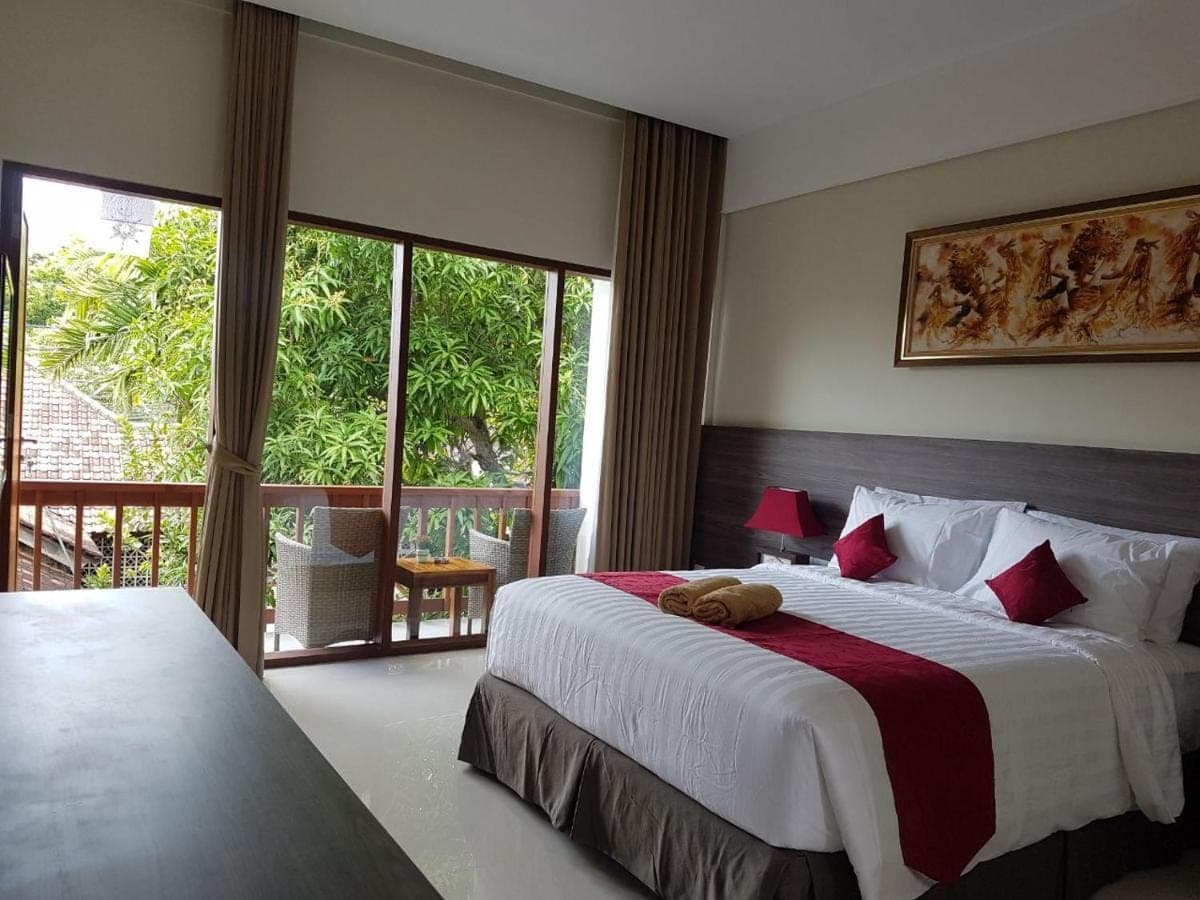 a bedroom with a bed with a teddy bear on it at Puri Kesari Guest House in Sanur