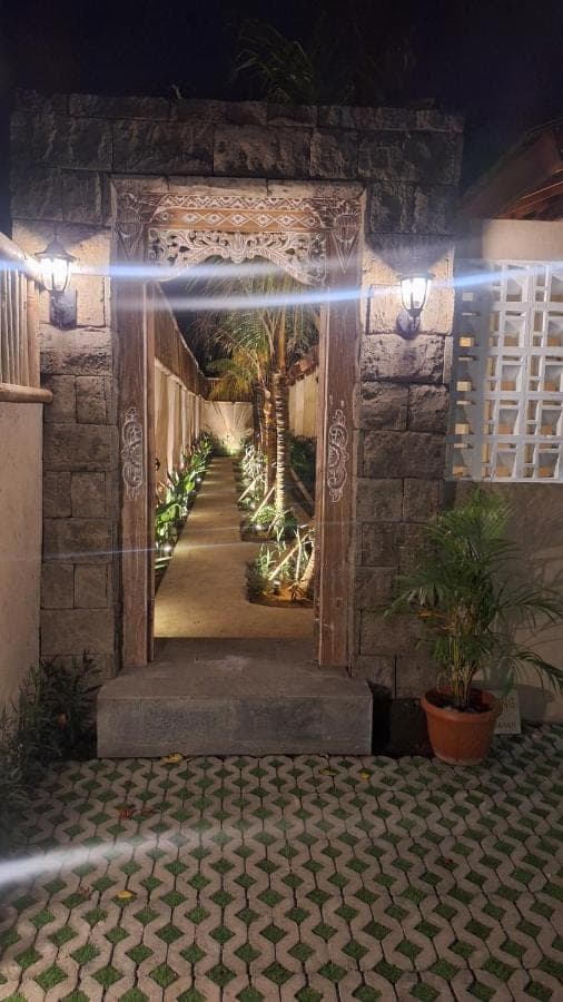 an entrance to a building with a walkway with lights at NOKA ULUWATU BED And BREAKFAST in Uluwatu