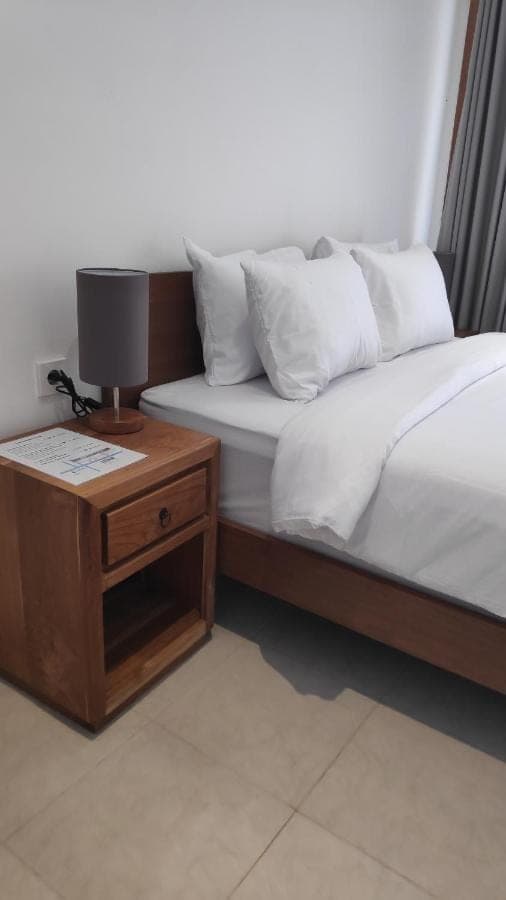 a bedroom with two beds and a table with a lamp at NOKA ULUWATU BED And BREAKFAST in Uluwatu
