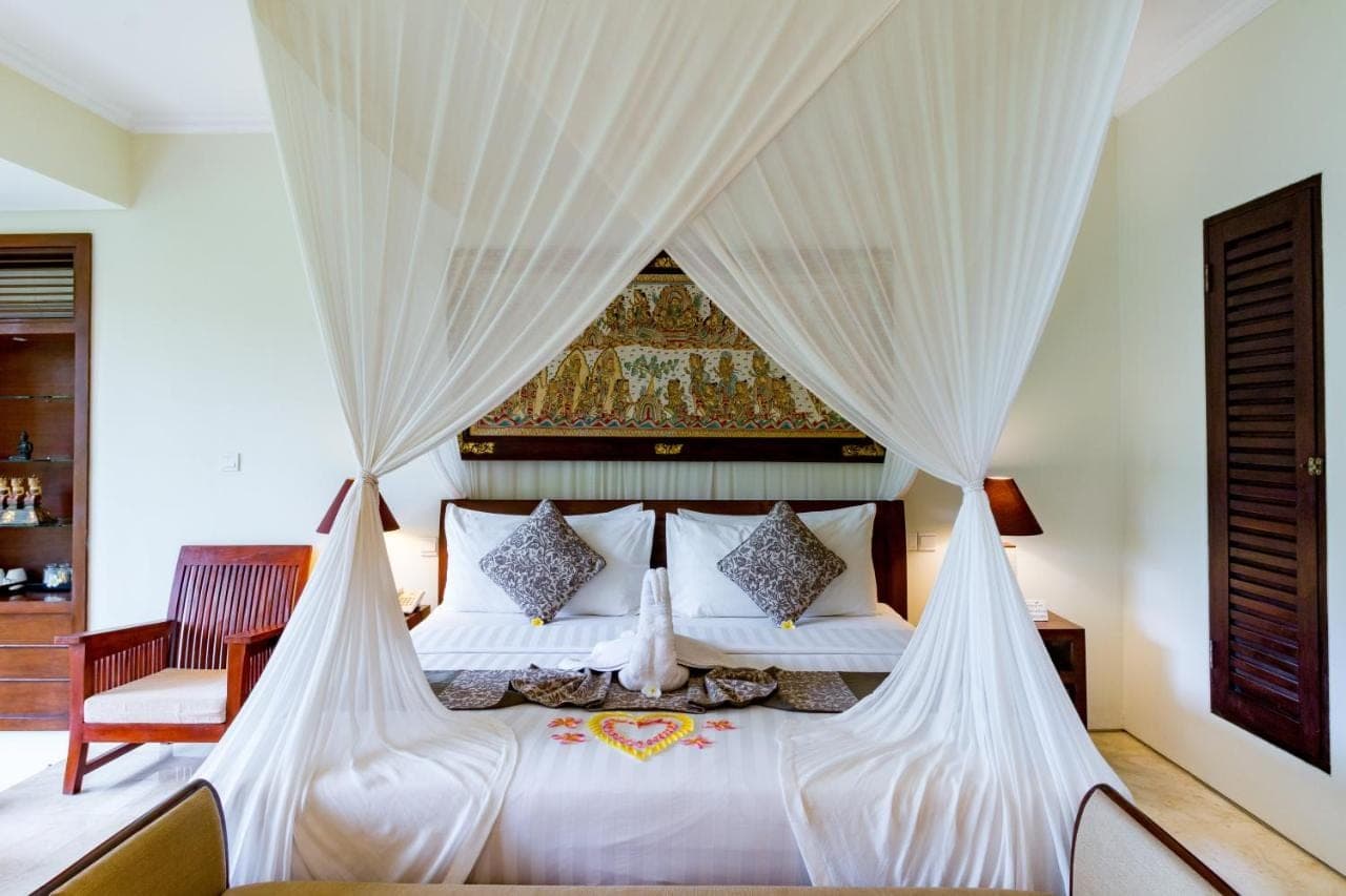a bedroom with a white bed with curtains at Cepik Villa Sidemen by AGATA in Sidemen