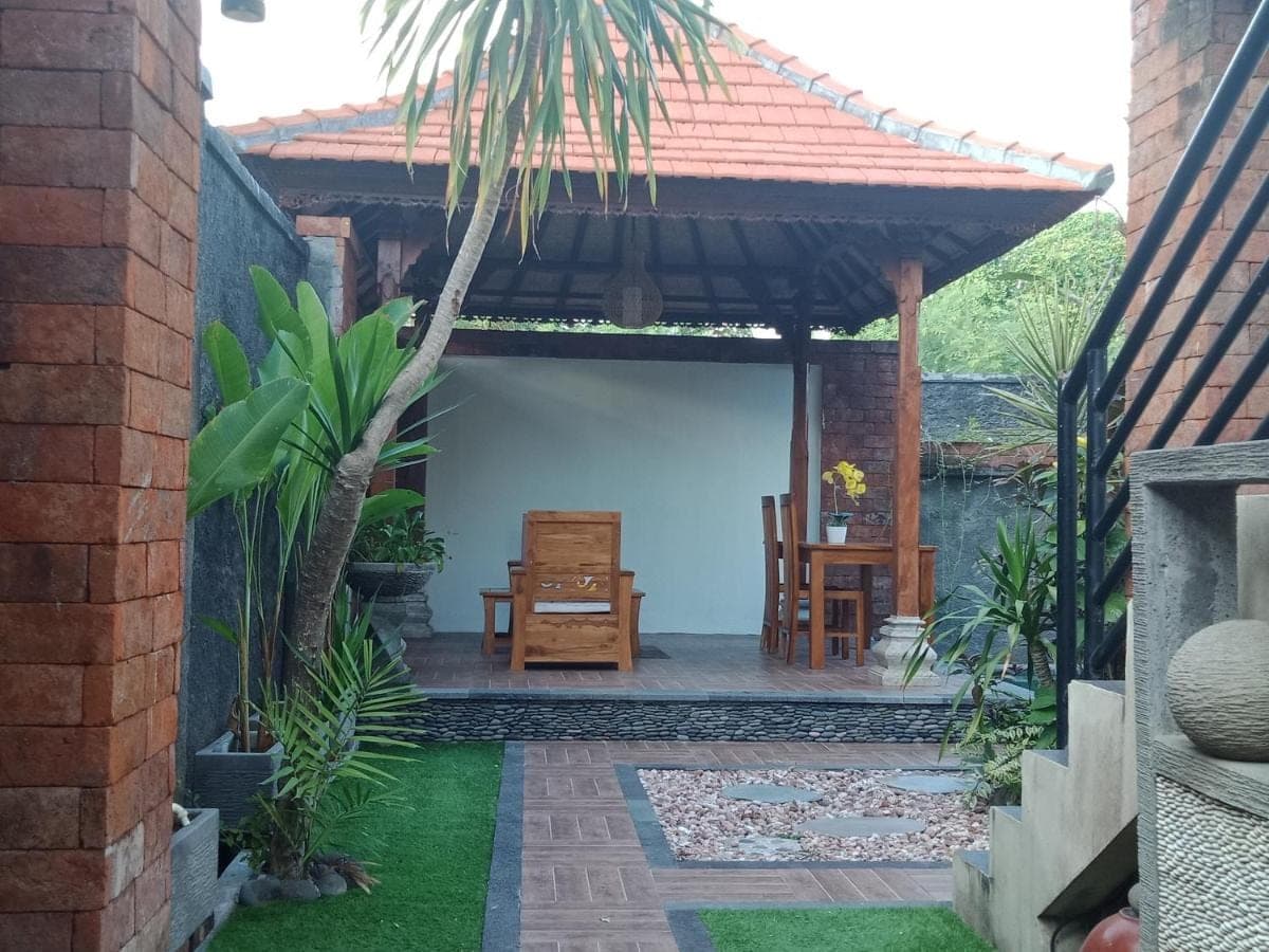 a patio of a house with a table and a chair at D'puja Home Stay and Spa in Nusa Dua