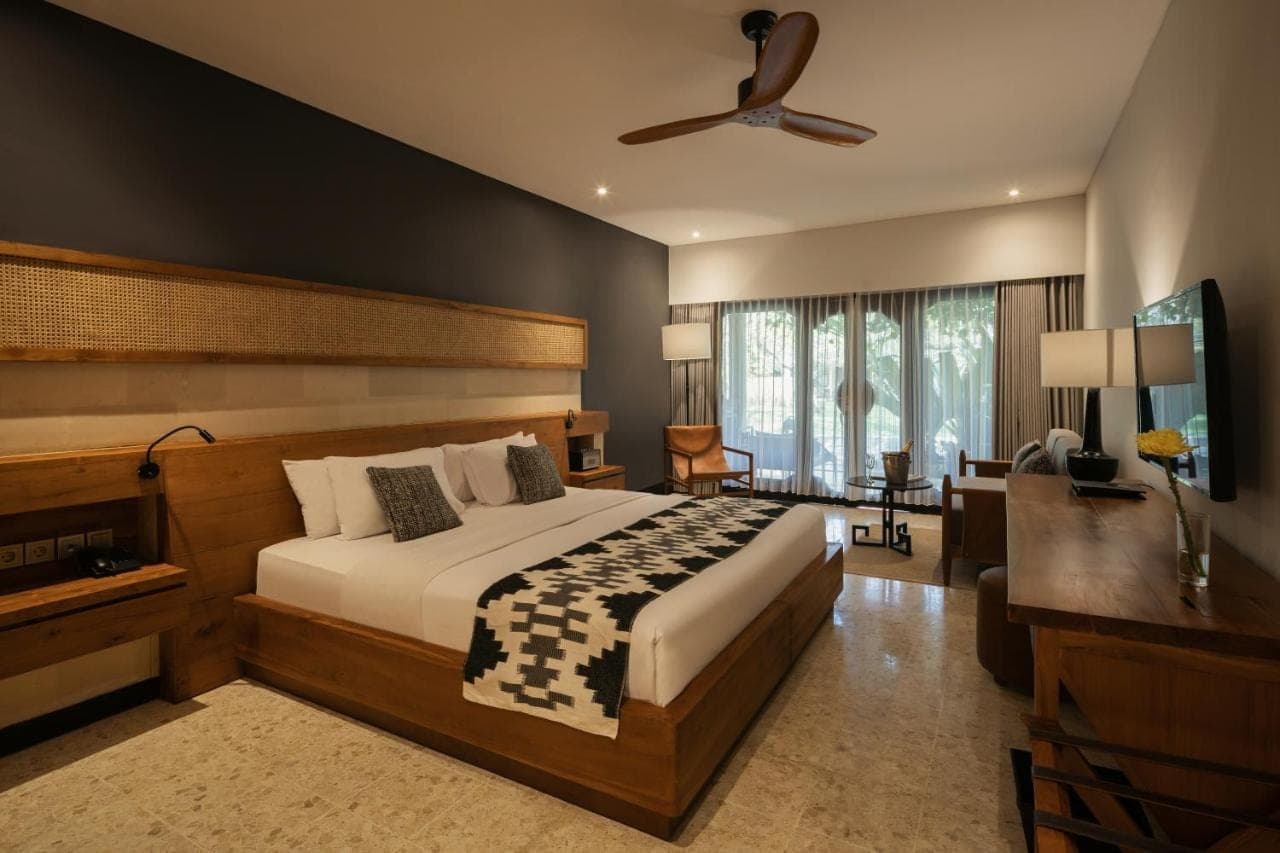 a bedroom with a large bed and a ceiling fan at Sadara Resort in Nusa Dua