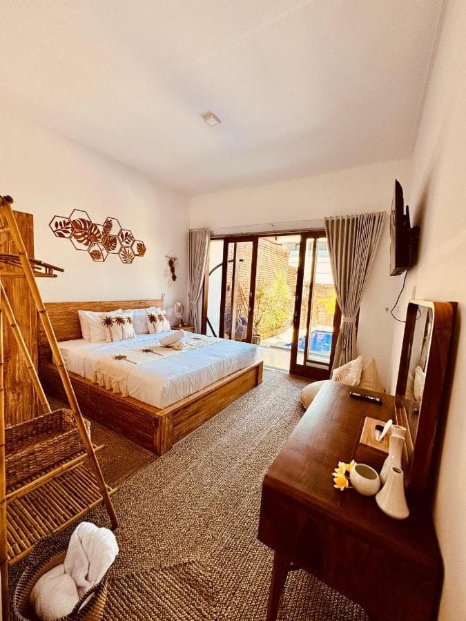 a large bedroom with a bed and a staircase at Nita Villa Bali in Canggu