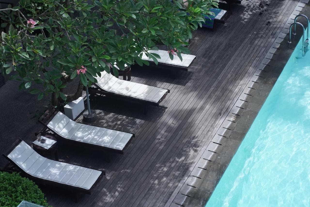 an overhead view of a deck with chairs and a swimming pool at The Vira Bali Boutique Hotel & Suite in Kuta