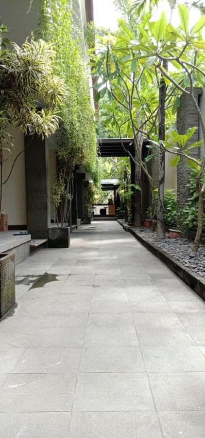 an empty hallway in a building with trees and plants at 21 Lodge in Nusa Dua