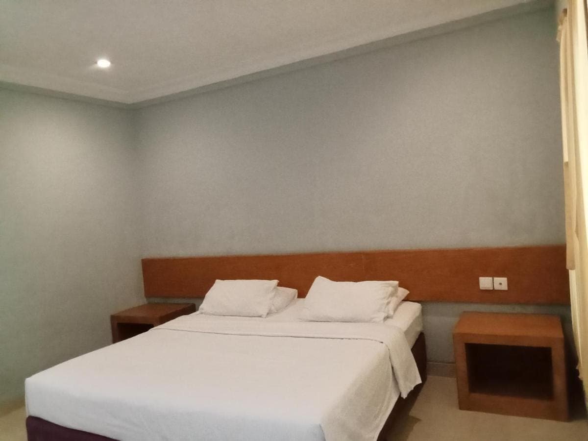 a bedroom with two beds with white sheets at 21 Lodge in Nusa Dua