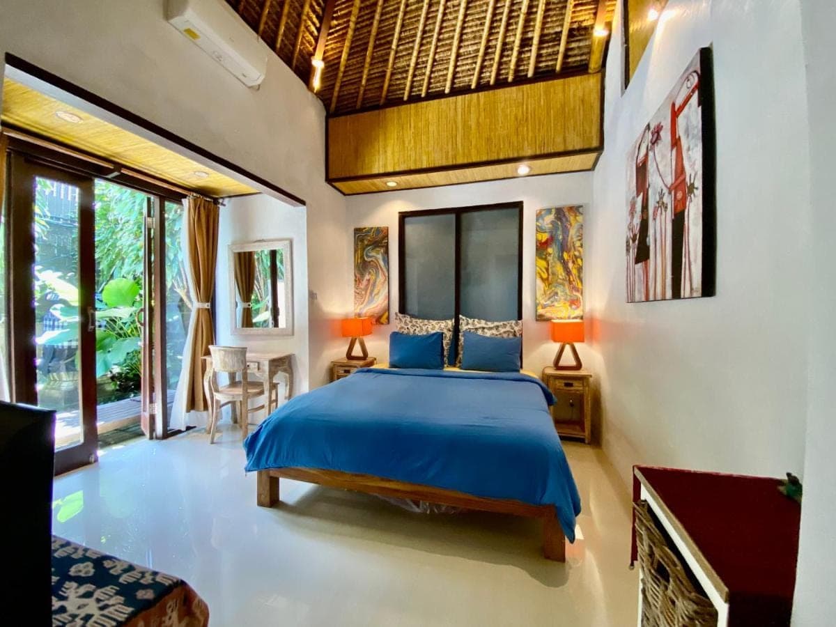 a bedroom with a blue bed in a room at Little Tree House in Sanur