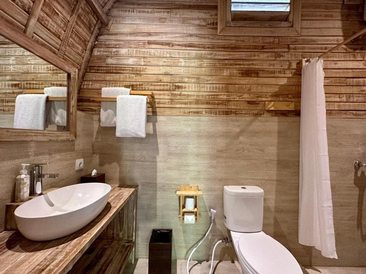 a bathroom with a white toilet and a sink at Tanhana Villa Canggu in Canggu