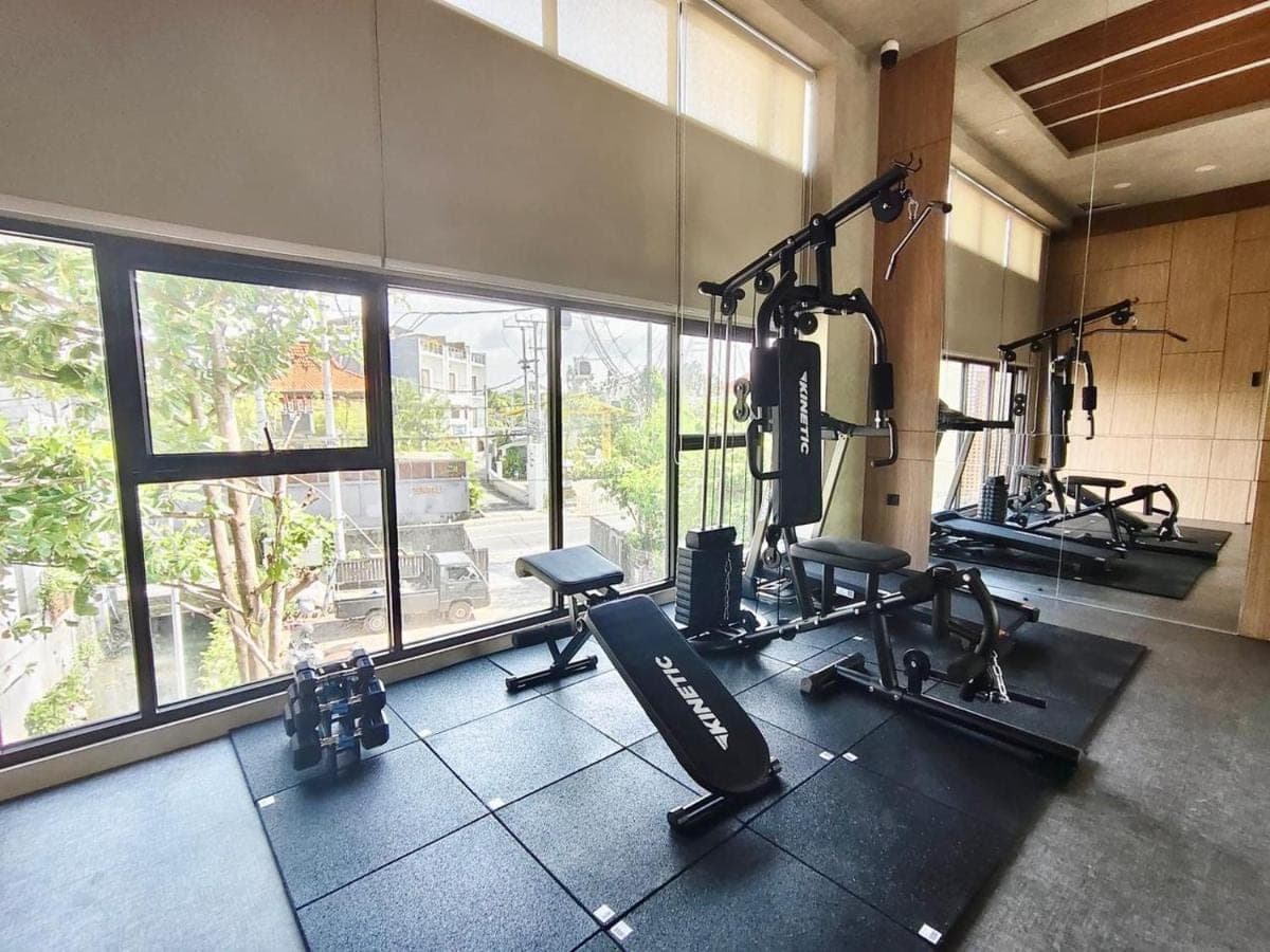 a gym with several treadmills and machines in a room at JJ JIVANA Bali in Canggu