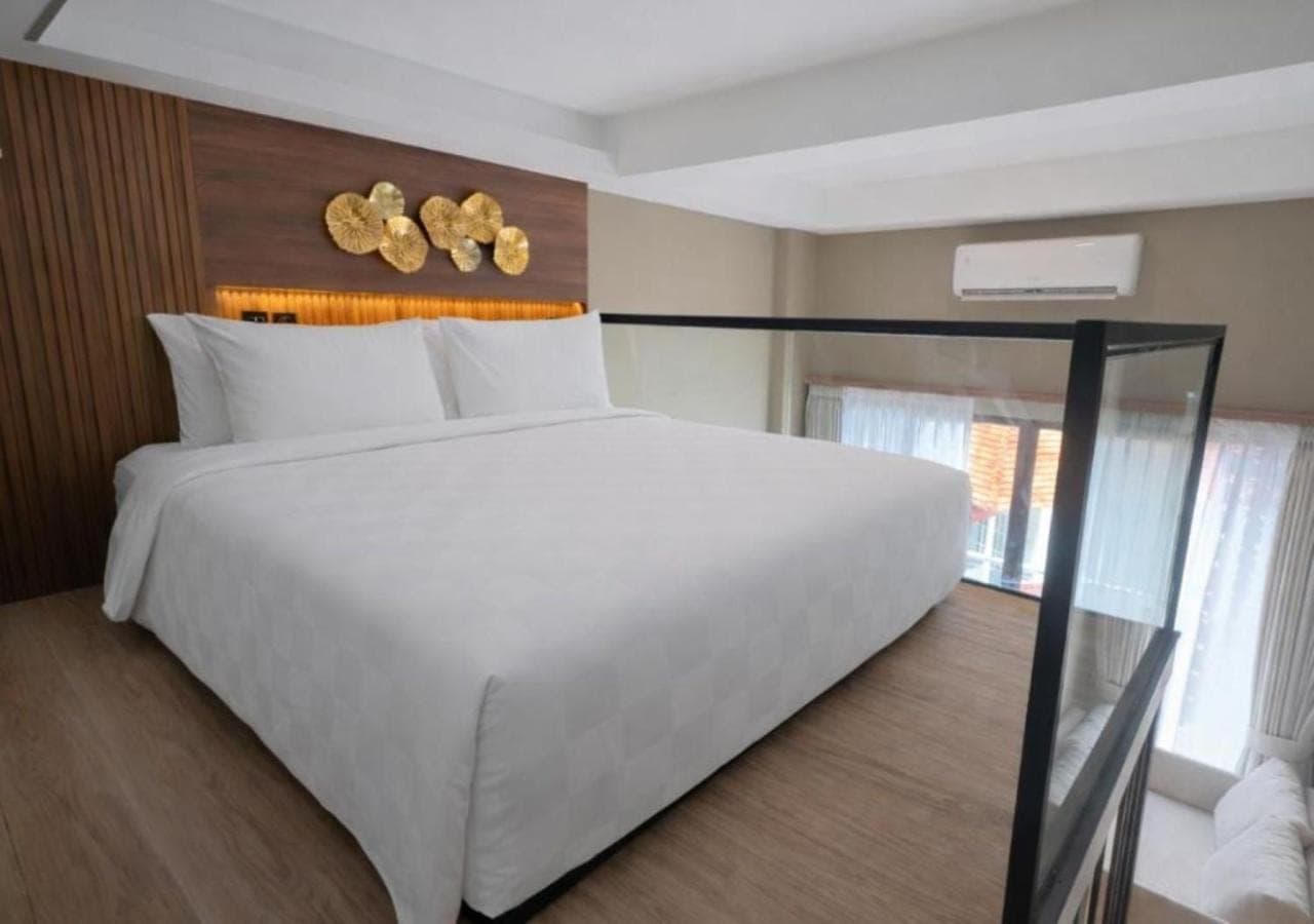 a bedroom with a large white bed and a window at JJ JIVANA Bali in Canggu
