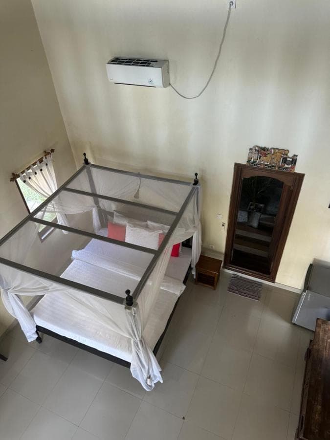 a room with a bed with a glass table at Tradisi Villas in Amed