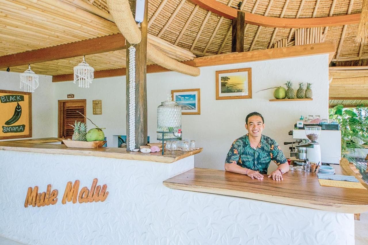 a man sitting at a counter in a restaurant at Mule Malu in Uluwatu