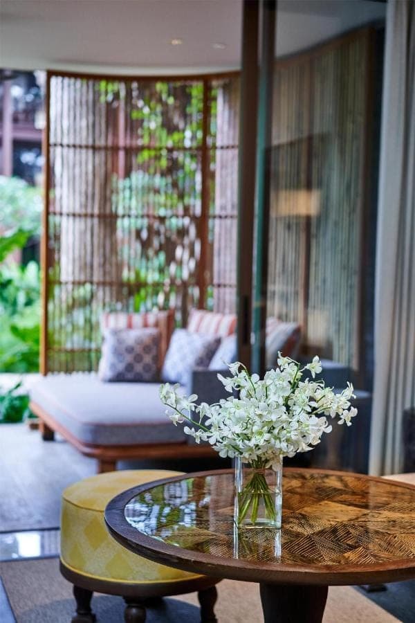 a vase of flowers on a table in a living room at Andaz Bali, By Hyatt in Sanur