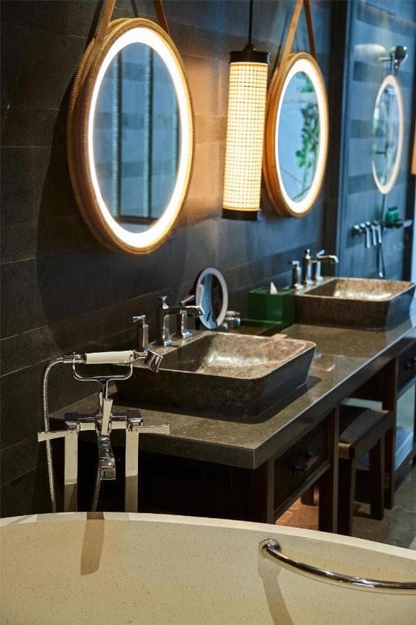 a bathroom with two sinks and three mirrors at Andaz Bali, By Hyatt in Sanur