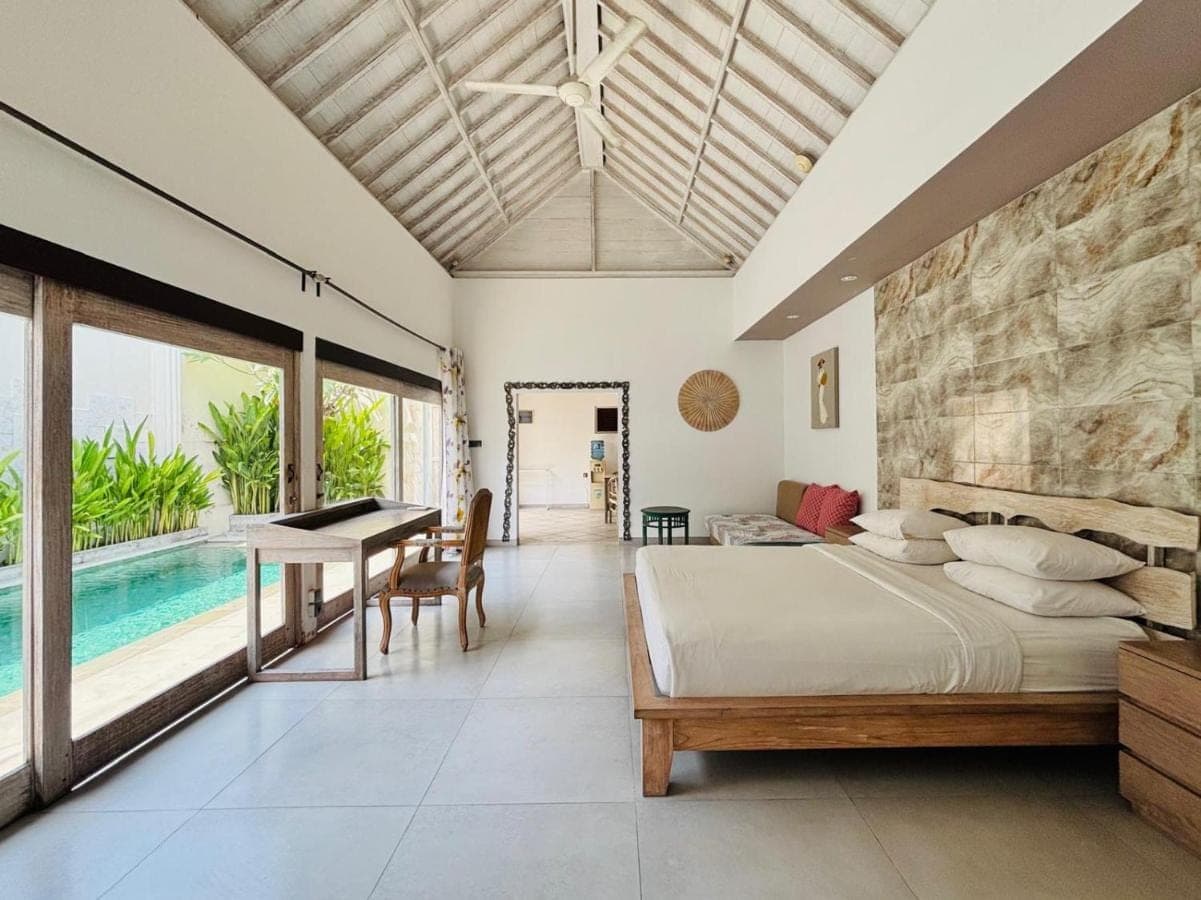 a bedroom with a bed and a pool at Zoe Villa Canggu Bali in Canggu
