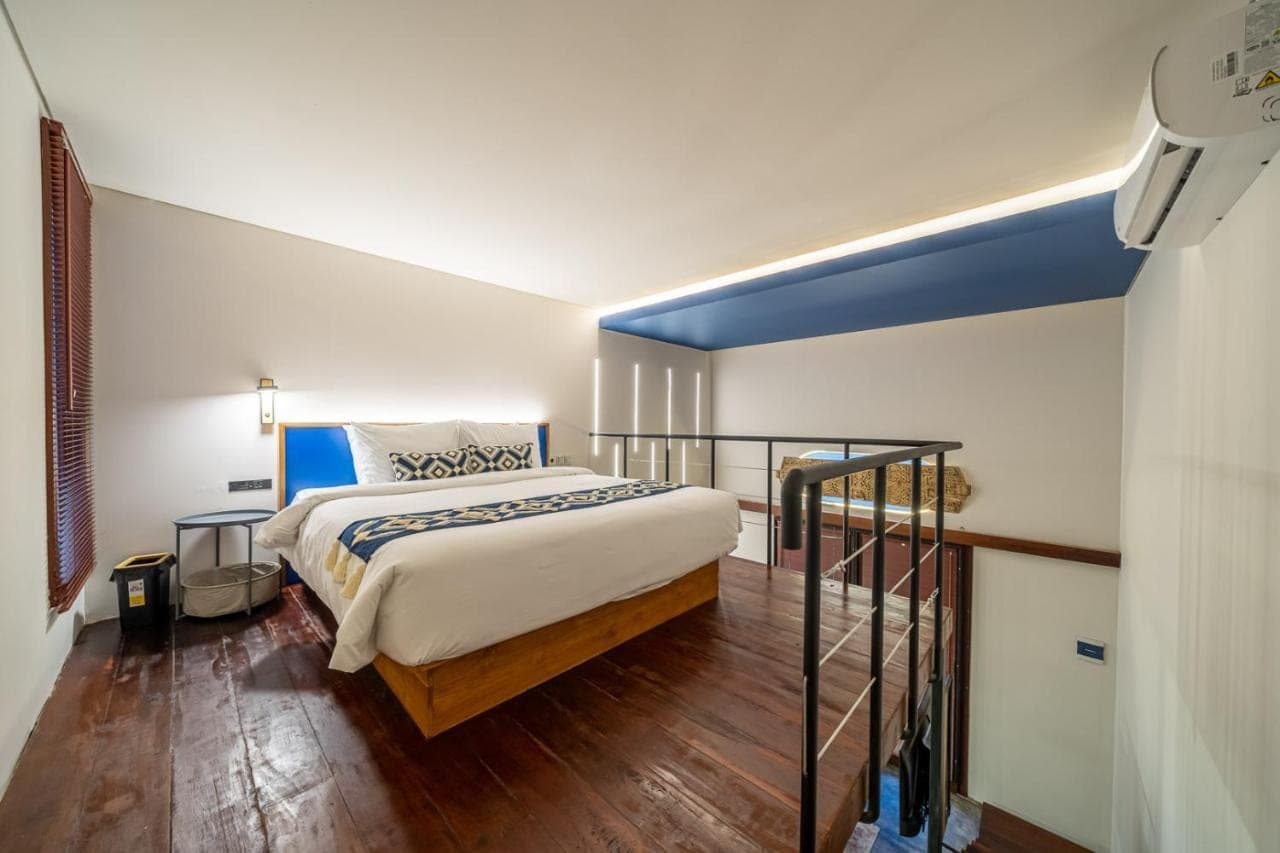 a bedroom with a king sized bed with a blue accent at First 5 Loft near Seminyak in Seminyak