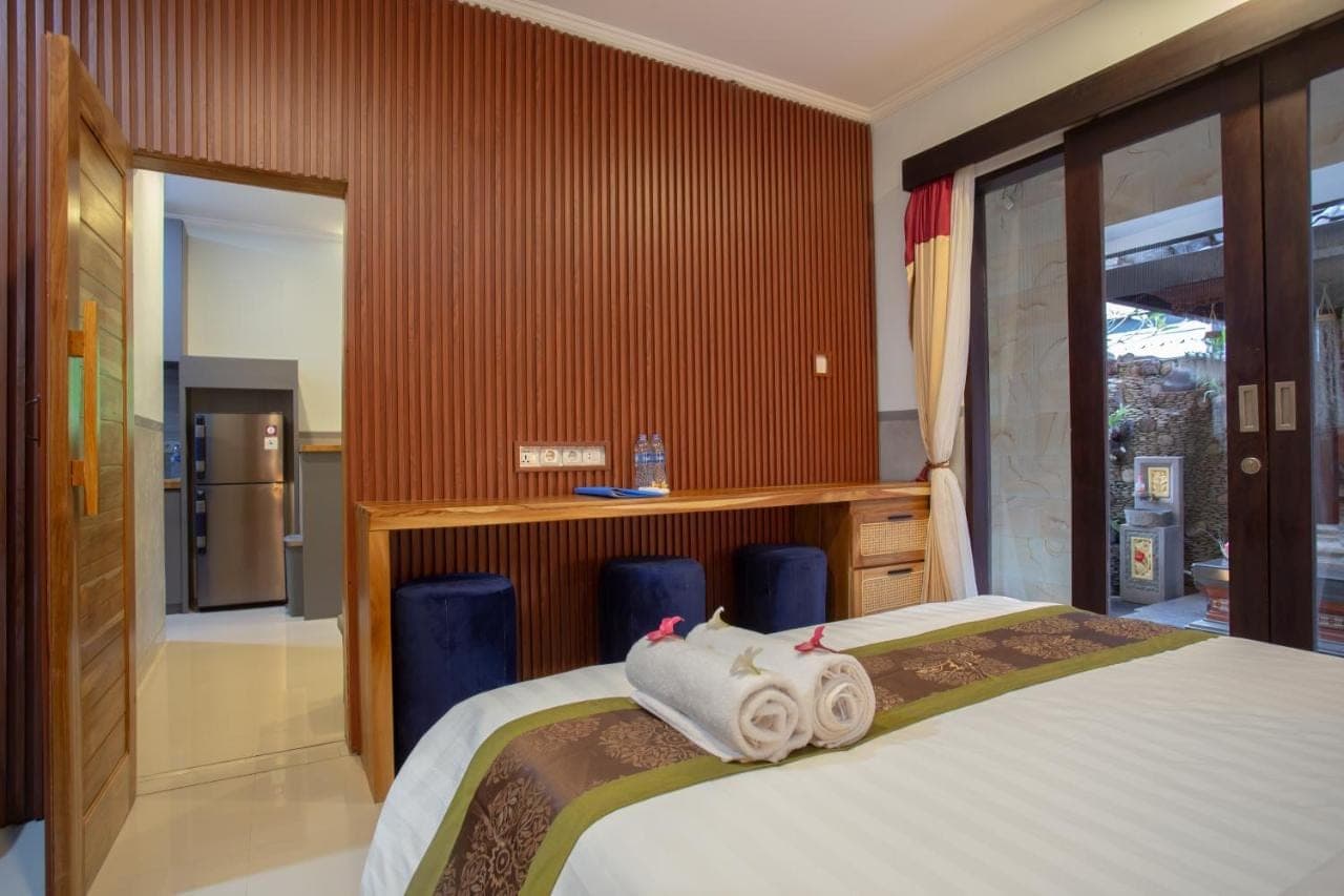 a bedroom with a bed with towels on it at Kubu Indah Homestay Sanur in Sanur